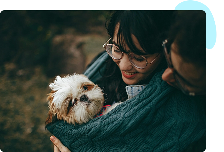 A woman holding a dog in her arms.